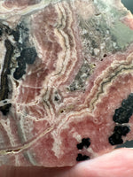 Natural Rhodochrosite Slab #17 – Pink Banded Mineral Specimen with Black Matrix
