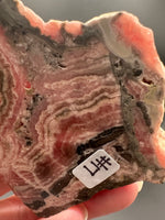 Natural Rhodochrosite Slab #17 – Pink Banded Mineral Specimen with Black Matrix